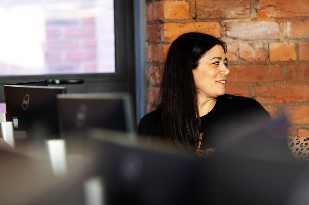 Woman looking behind with monitors
