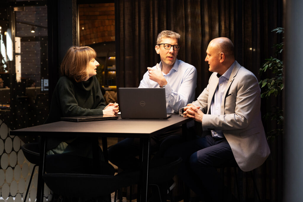 Three colleague meeting at a small table