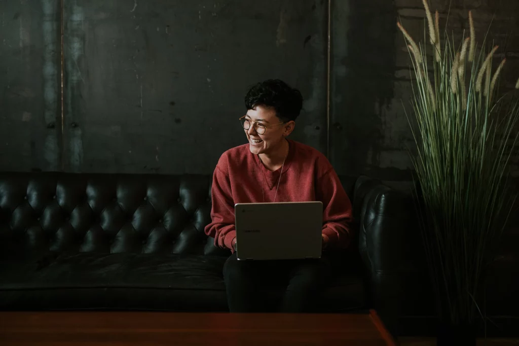 Woman smiling while using a laptop